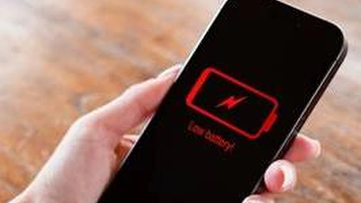 Elinde düşük pil uyarısı görünen akıllı telefon tutan kişi