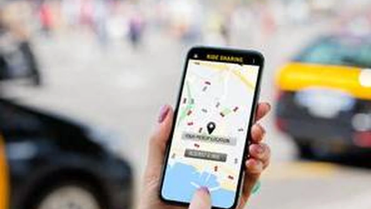 Taksi yanında telefonuyla uygulama kullanan kişinin yakın planı