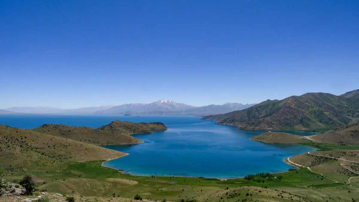 Dağlarla çevrili geniş mavi göl manzarası
