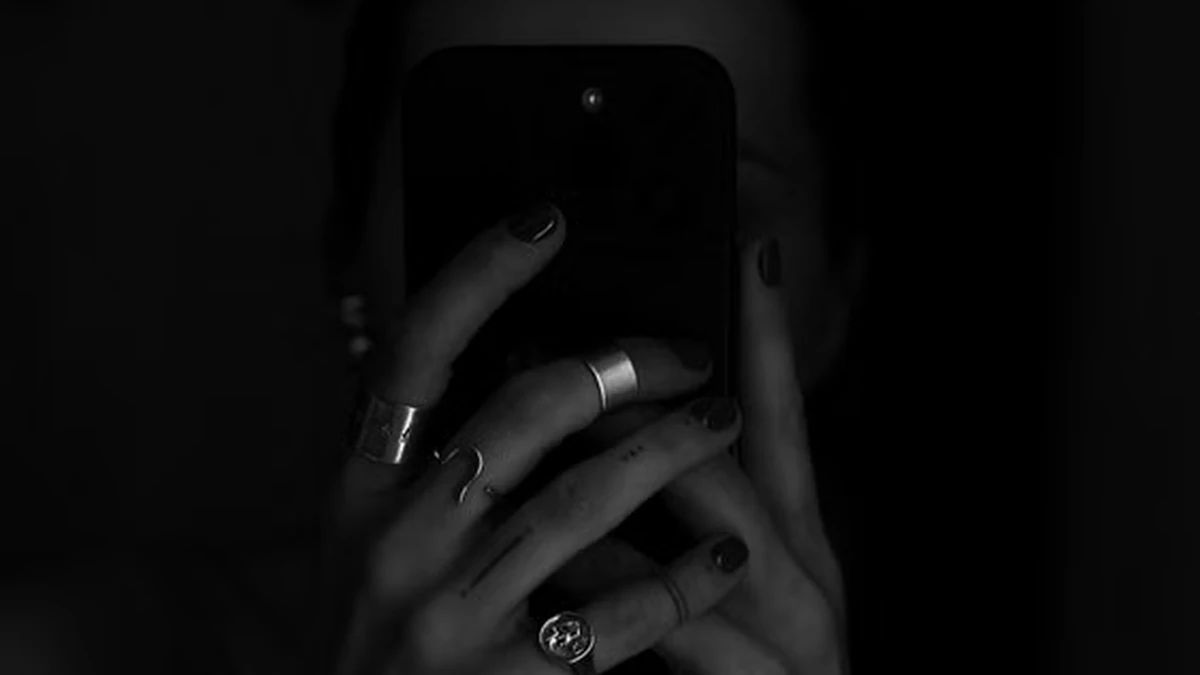 Karanlık ortamda telefonuna bakan gizemli kişi