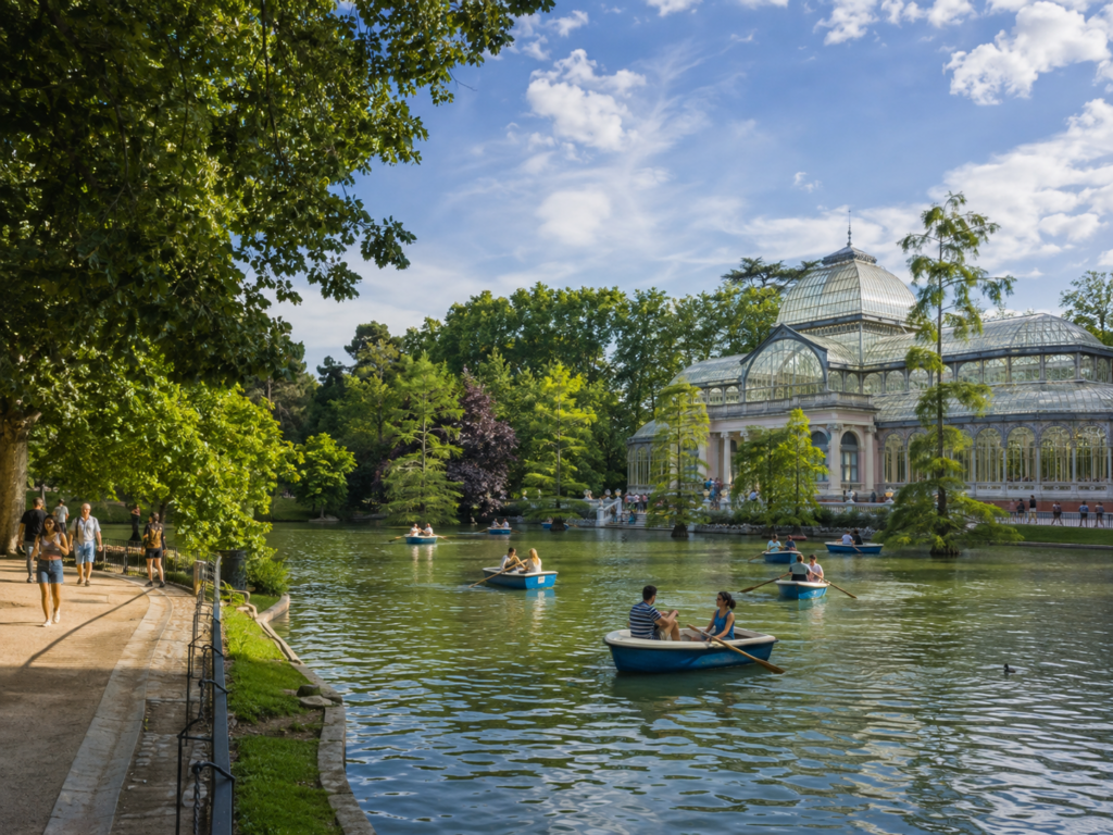 Madrid El Retiro Parkı'nda gölde gezinen kayıklar ve Kristal Saray manzarası