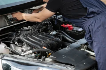 Kaputu açık araçta motor bölmesini kontrol eden usta