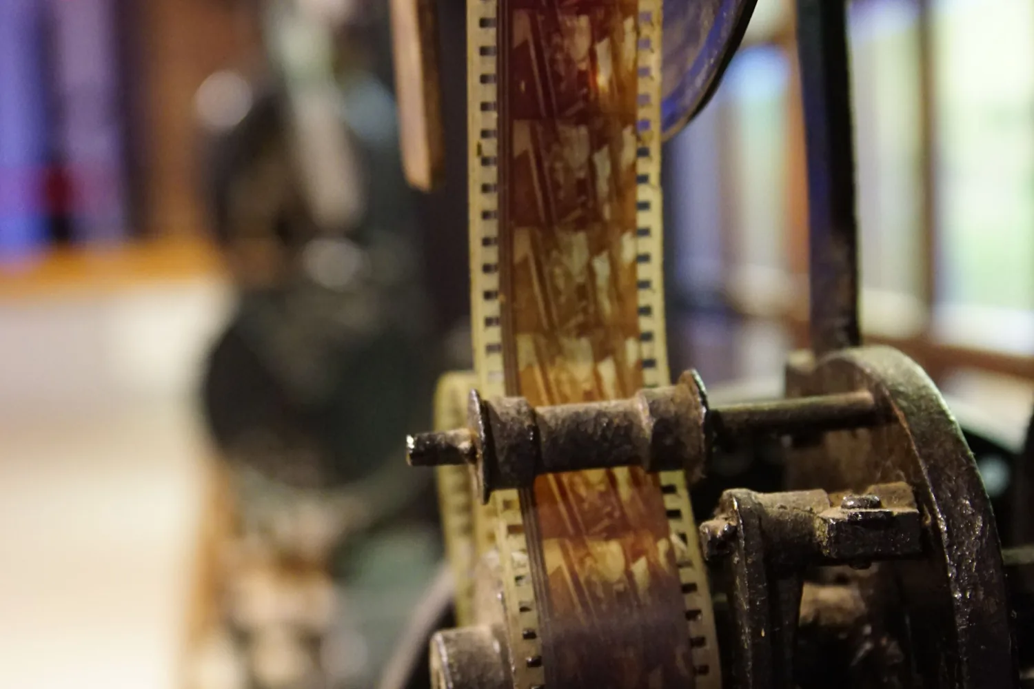 Bir müzede sergilenen eski sinema makinesinin makaralarından geçen film şeridi